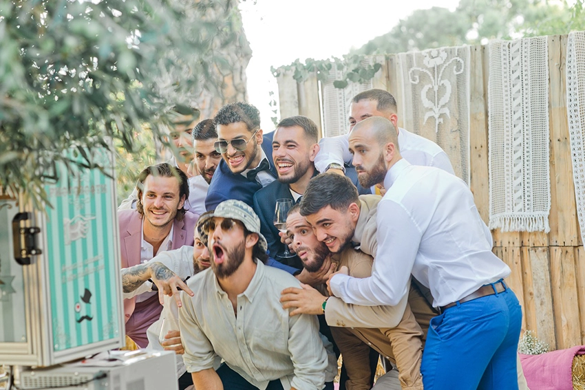 Les amis du mari&eacute; devant le photobooh lors d'un mariage champ&ecirc;tre