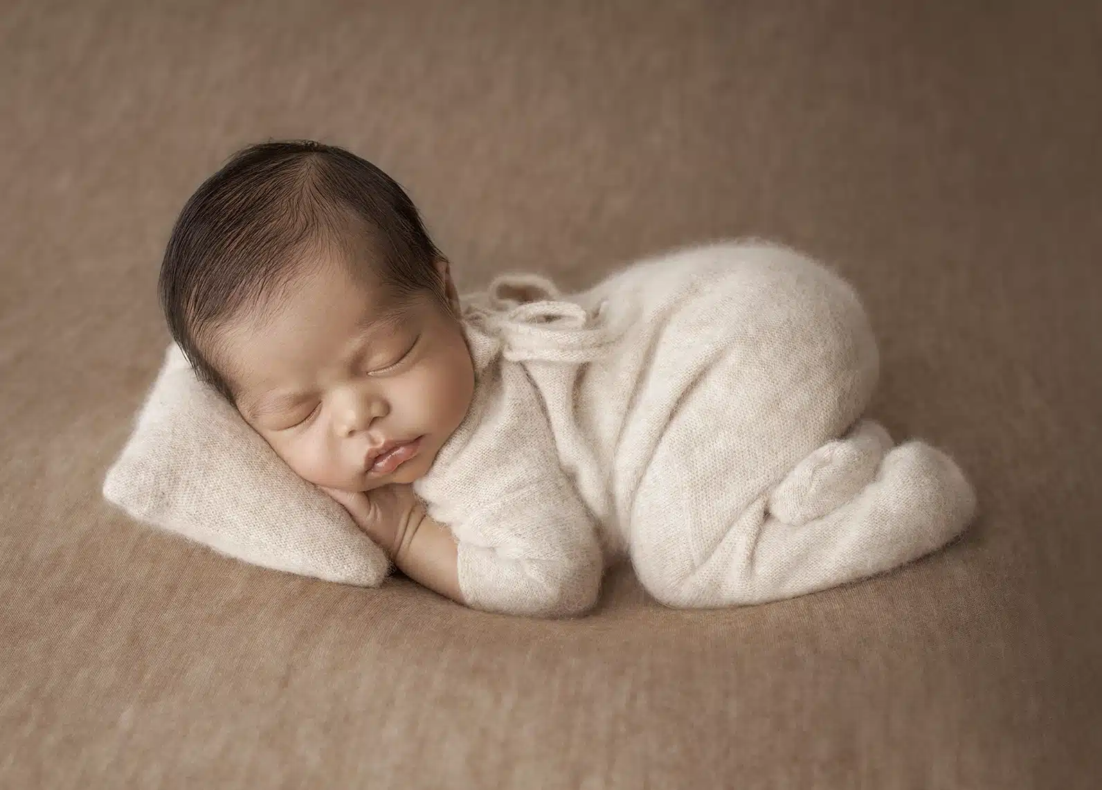 Photo d'un nouveau n&eacute; en position artistique r&eacute;alis&eacute; au studio de Tiana Photographe &agrave; Toulouse