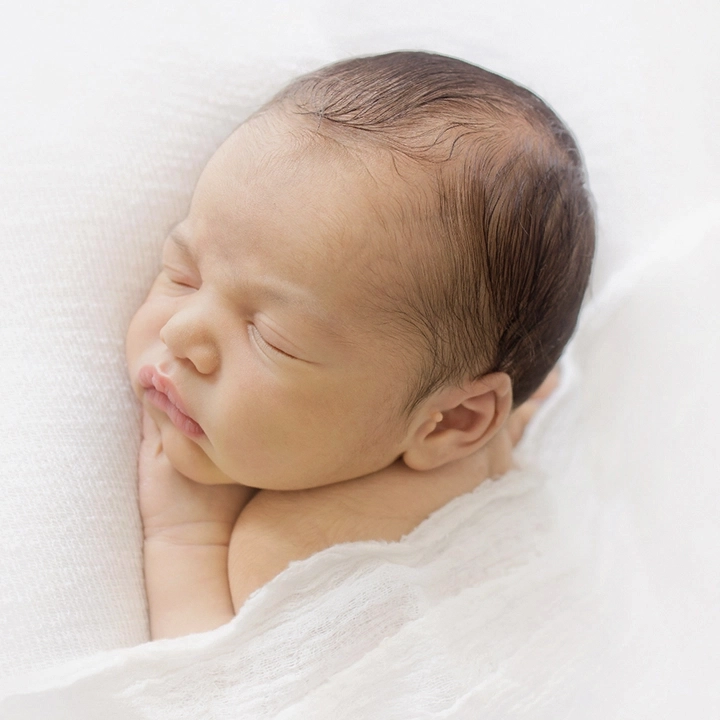 Photographie d'un nouveau n&eacute; de profil lors d'une s&eacute;ance photo artistique avec Tiana Photographe Toulouse