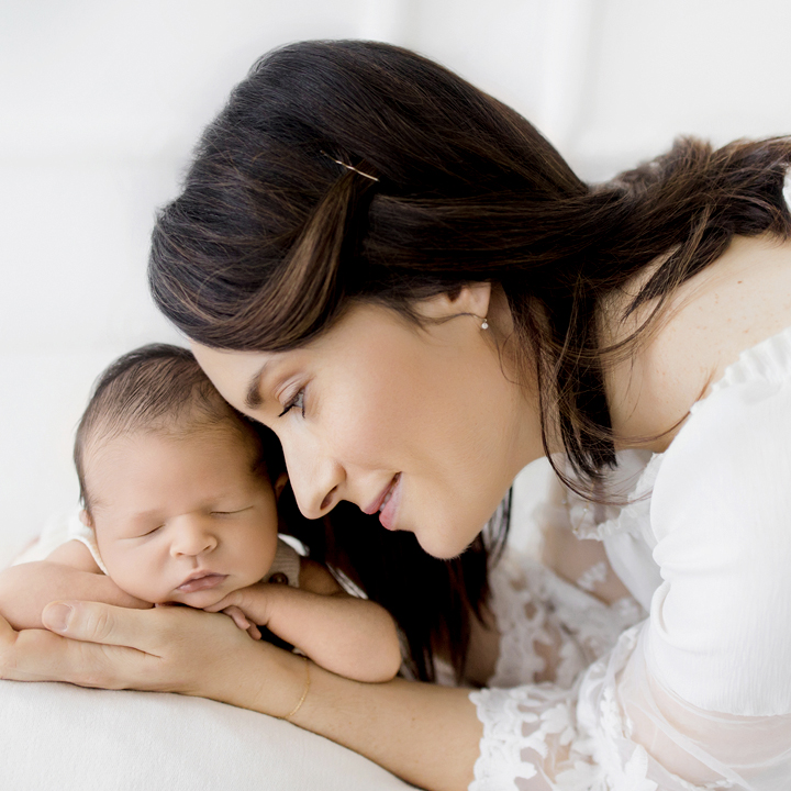 Photographie d'une maman qui tient son b&eacute;b&eacute; dans ses mains lors d'une s&eacute;ance photo avec Tiana Photographe Toulouse