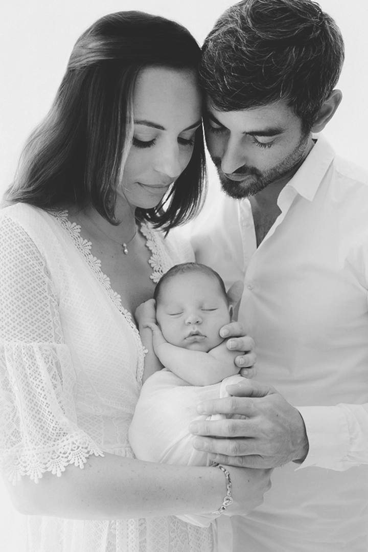 Photo des parents qui tiennent leur b&eacute;b&eacute; dans leur bras lors d'une s&eacute;ance photo avec Tiana Photographe Toulouse