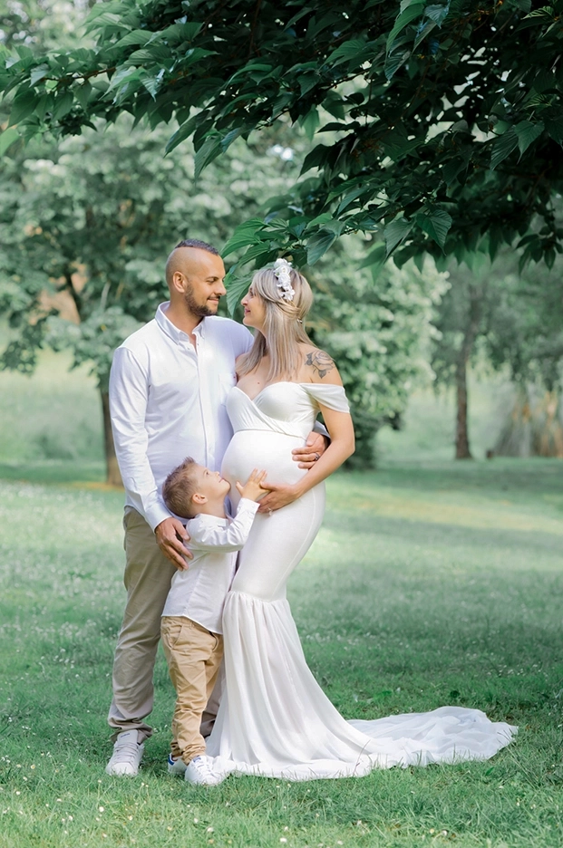 Photo de famille d'une maman enceinte dans un parc lors d'un shooting photo